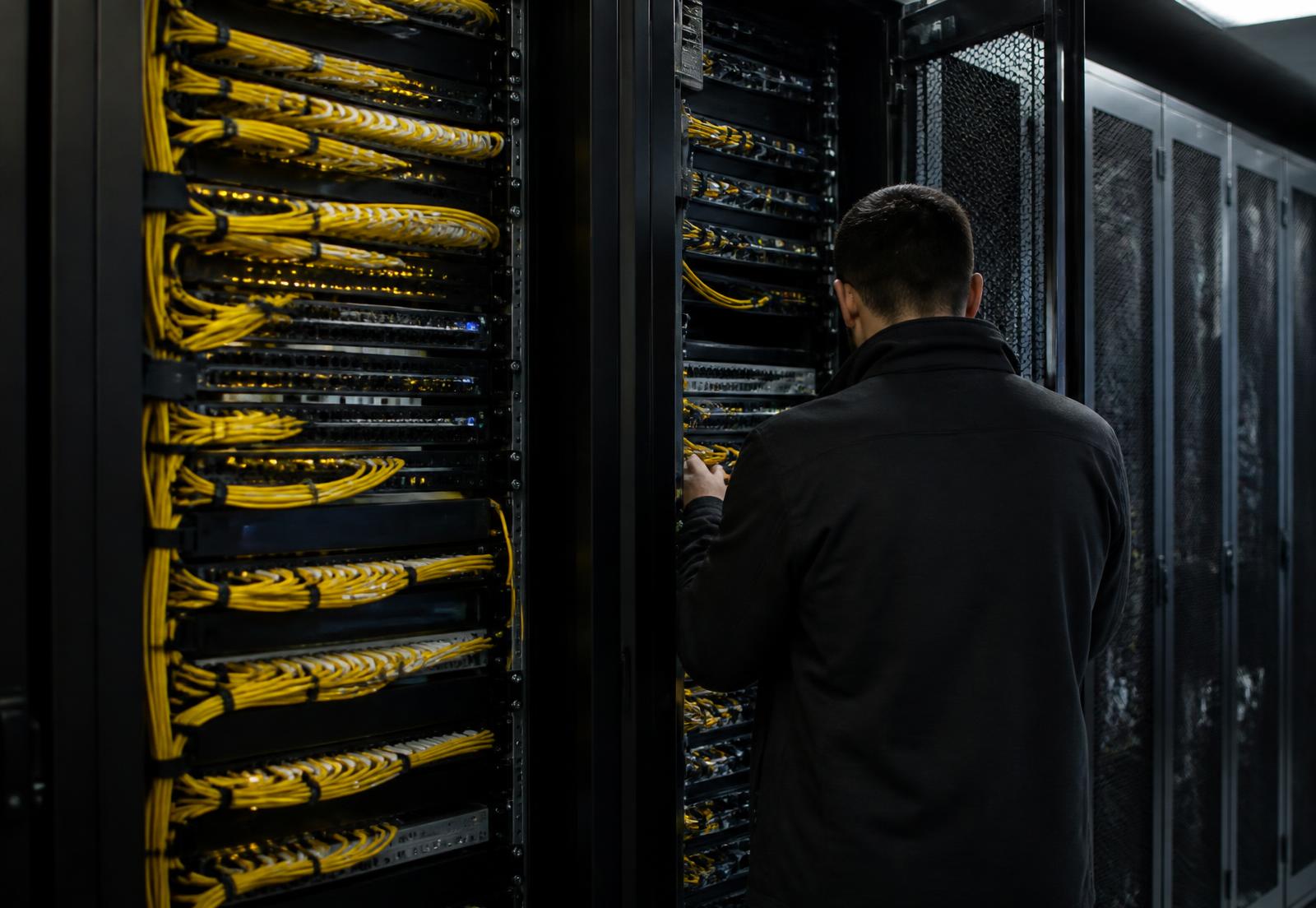 Baies de data center avec câblage et armoire électrique vérifiée par un technicien